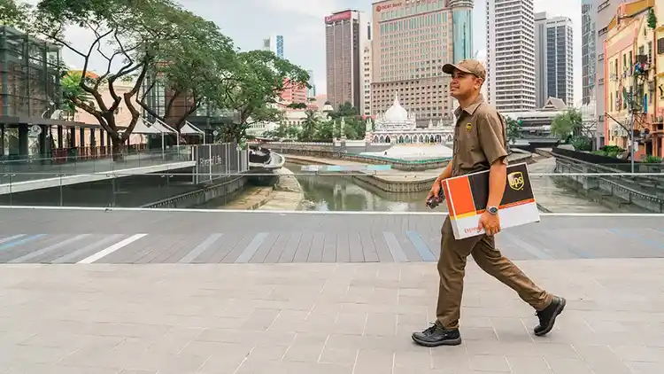 UPS delivery man holding package and walking