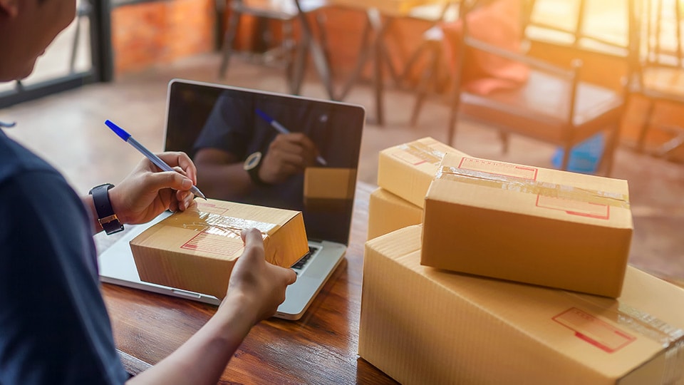 Cliente comercial de UPS escribiendo en un paquete