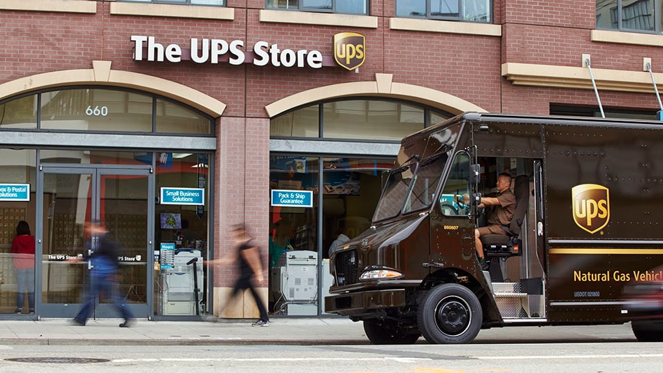 Conductor de UPS dejando un paquete