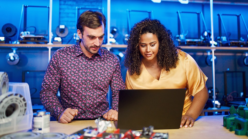 Hombre y mujer rastreando un paquete UPS en una computadora portátil