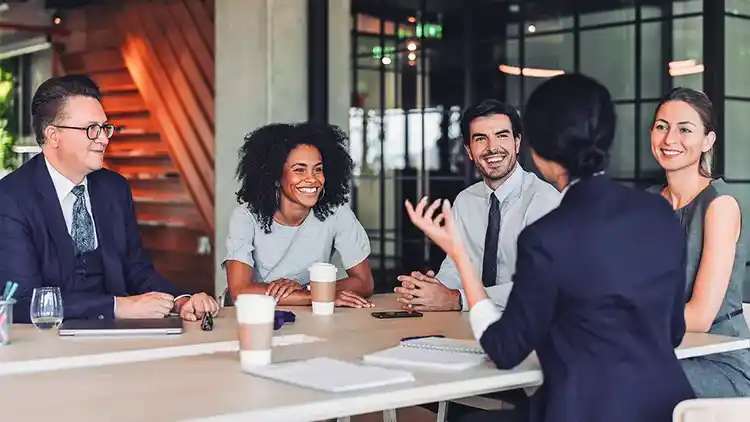 Eine Gruppe von Personen bei einem Arbeitsgespräch.