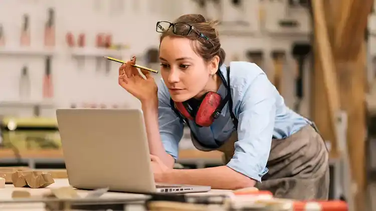 Femme dans un studio de travail utilisant un ordinateur portable