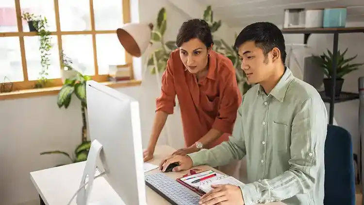 Two people looking at computer learning how to file a claim with UPS