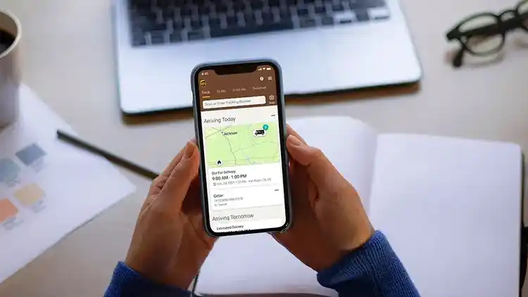 Bild på händer med en mobiltelefon som visar mobilspårningsappen på skärmen.