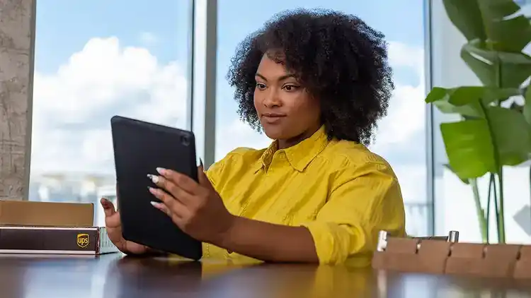 Woman looking at My Choice for Business dashboard on a tablet.